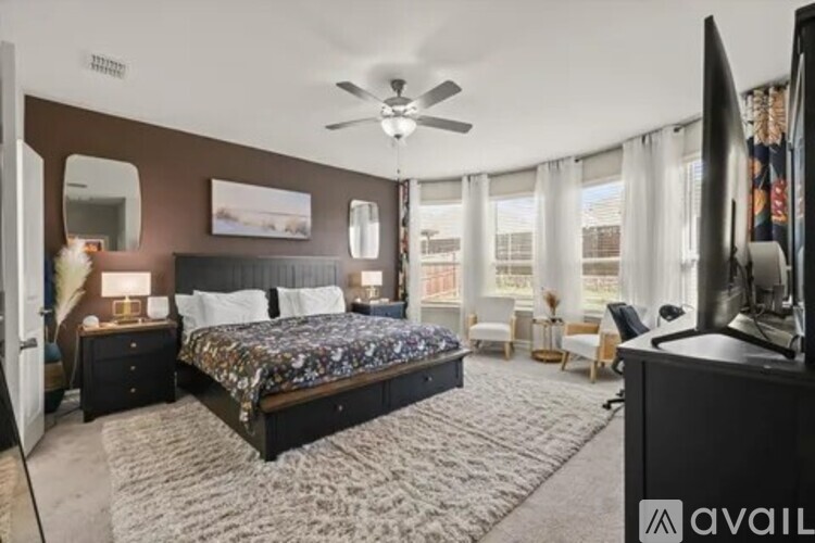 A bedroom with a large bed and a flat screen TV.