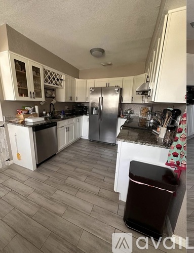 A kitchen with a refrigerator, stove, and oven.