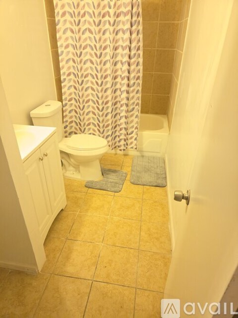 A bathroom with a toilet, sink, and shower curtain.