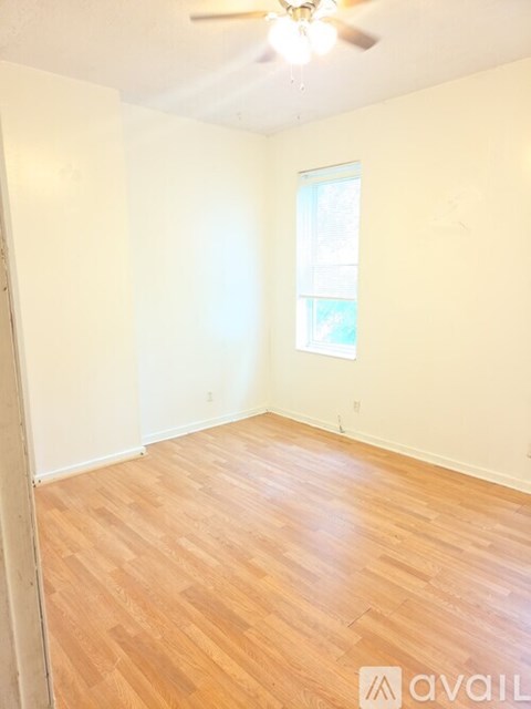 A room with wooden flooring and a ceiling fan.