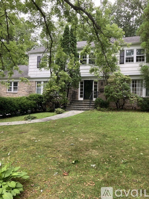 A white house with a green lawn in front.