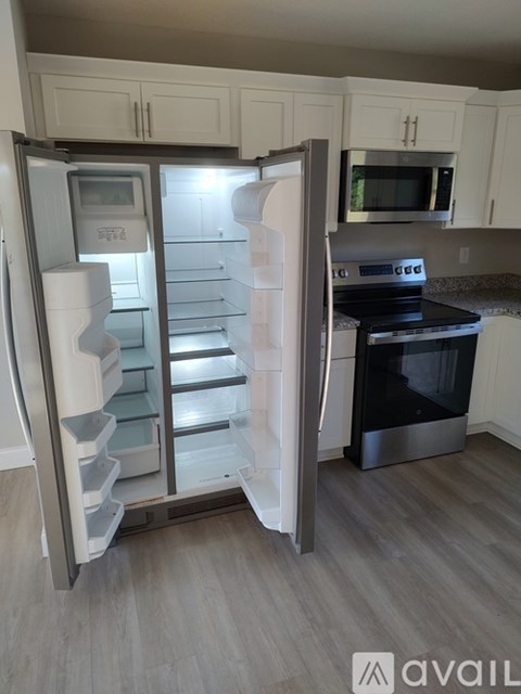 A modern kitchen with a stainless steel refrigerator and oven.