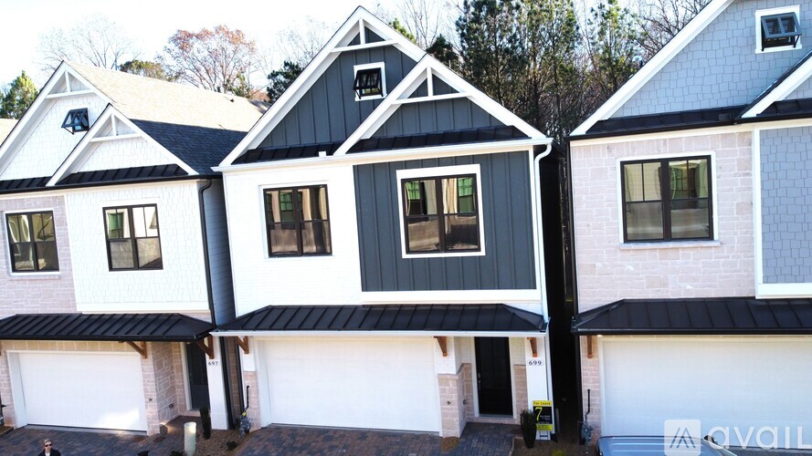 A row of houses with garages and a sign that says "available".