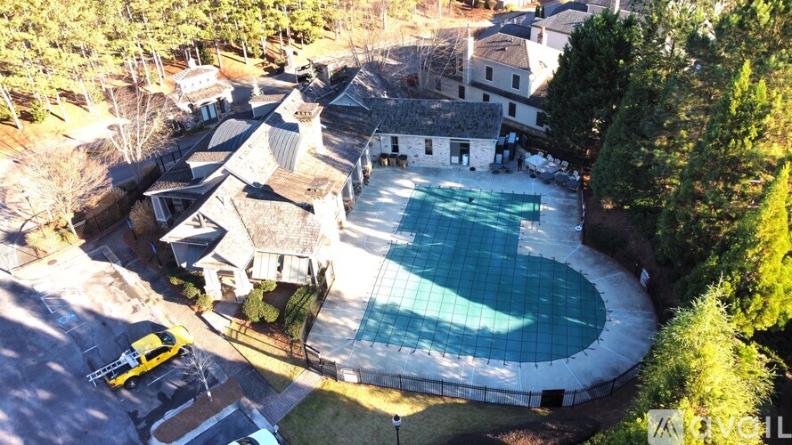 A yellow car is parked in front of a house with a pool.