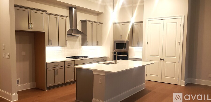 A kitchen with a white island and a stove top oven.