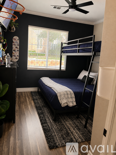 A bedroom with a bunk bed and a ceiling fan.