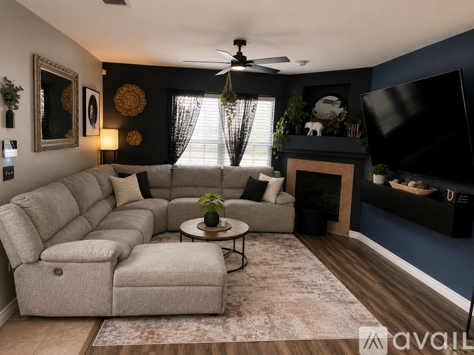 A living room with a grey sectional sofa, a coffee table, a fireplace, and a television.