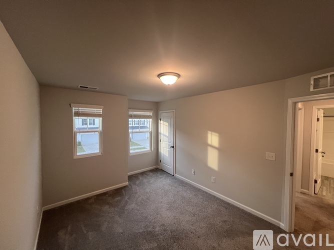 A spacious room with a window and a door leading to another room.