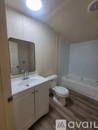 A bathroom with a toilet, sink, and bathtub.