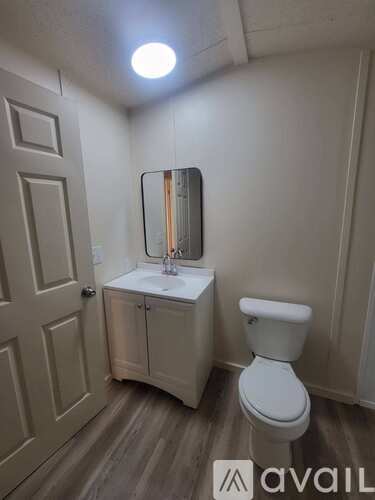A bathroom with a toilet, sink, and medicine cabinet.