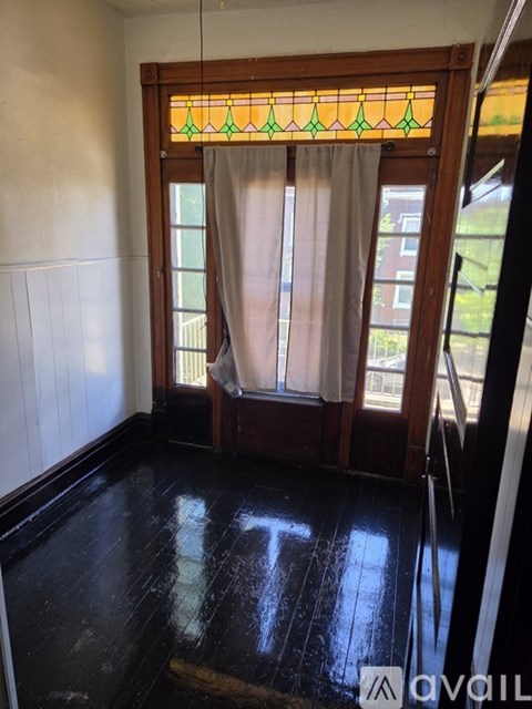 A room with a stained glass window and a wooden door.
