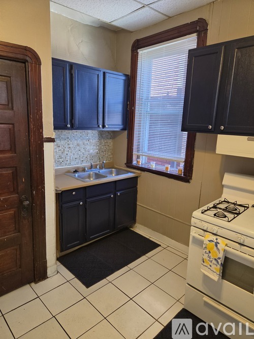 A kitchen with black cabinets and a white stove.