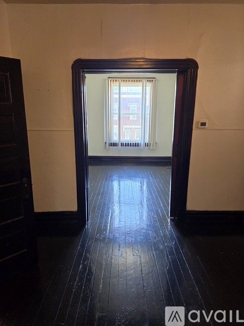 A mirror reflects a room with a window and a building outside.