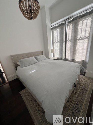 A bedroom with a large bed and a chandelier.