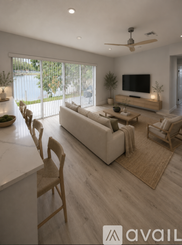 A modern living room with a large couch, a television, and a ceiling fan.