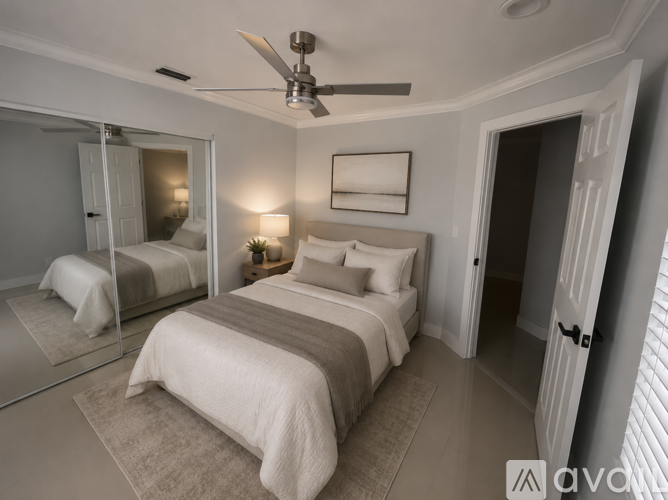 A bedroom with a large bed and a ceiling fan.