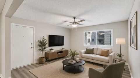 A living room with a white couch, a coffee table, and a ceiling fan.
