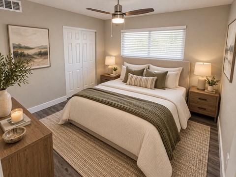 A bedroom with a bed, nightstands, and a ceiling fan.
