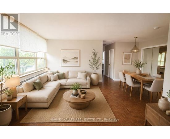 A well-lit, modern living room with a large sectional sofa, a coffee table, and a dining area.