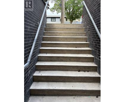 A set of concrete stairs with a metal railing on the side.