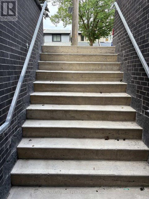 A set of concrete stairs with a metal railing on the side.