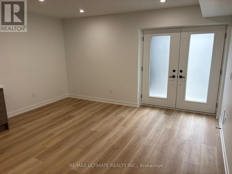 A room with a wooden floor and a white door.
