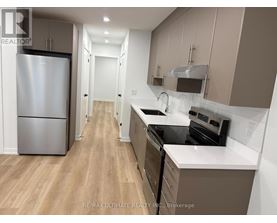 A kitchen with a refrigerator, stove, and oven.