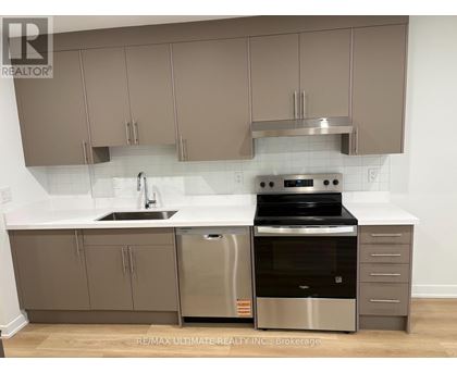 A modern kitchen with stainless steel appliances and beige cabinets.