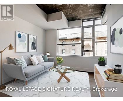 A living room with a grey couch, a glass coffee table, and a large window.