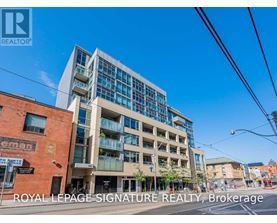 A modern multi-story building with glass windows and balconies is the focus of this image.