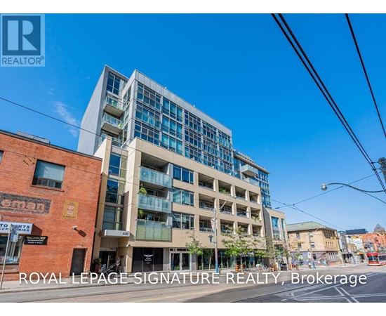 A modern multi-story building with glass windows and balconies is the focus of this image.