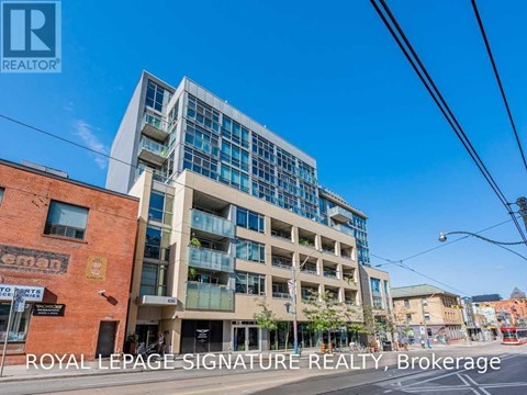 A modern multi-story building with glass windows and balconies is the focus of this image.