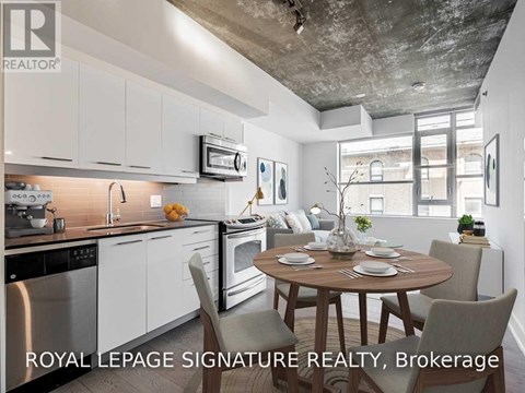 A modern kitchen with a dining table set for two.