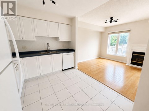 A kitchen with white cabinets and a black counter top.