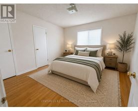 A bedroom with a bed, nightstands, and a plant.