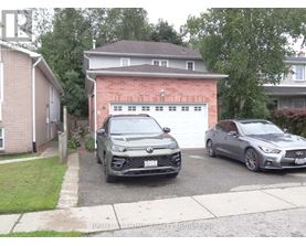 Two cars parked in front of a garage.