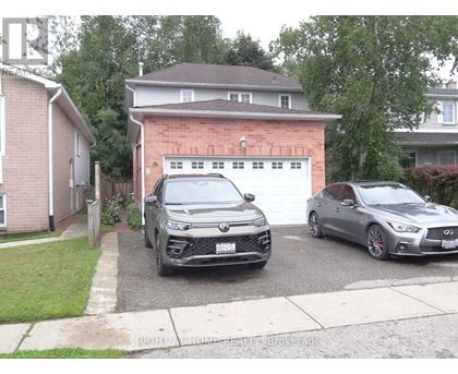 Two cars parked in front of a garage.