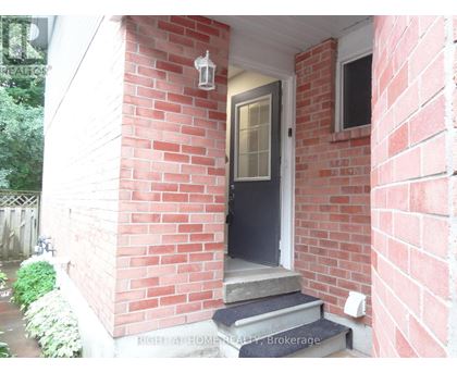 A red brick house with a black door and a small porch.