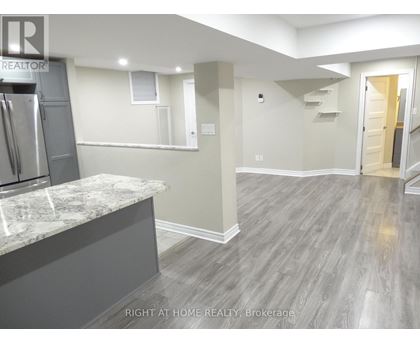 A kitchen with a marble countertop and a refrigerator.
