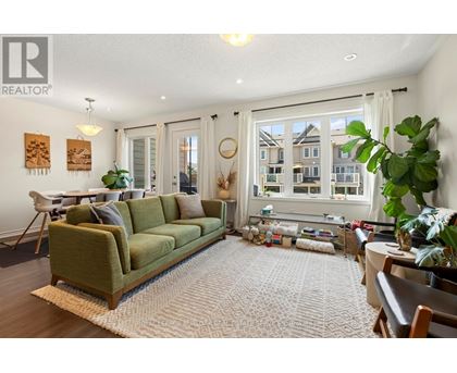 A living room with a green couch and a large window.