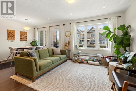 A living room with a green couch and a large window.