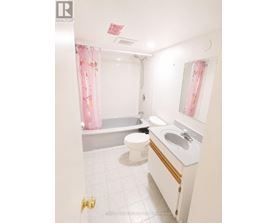 A white bathroom with a toilet, sink, and bathtub.