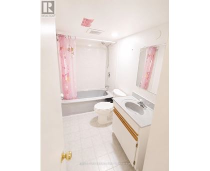 A white bathroom with a toilet, sink, and bathtub.