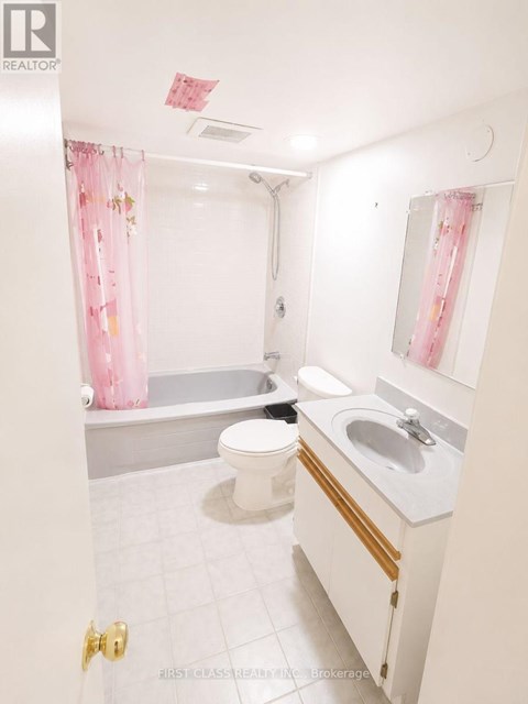 A white bathroom with a toilet, sink, and bathtub.