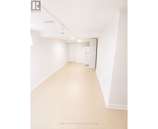 A white room with a tiled floor and a door on the right.