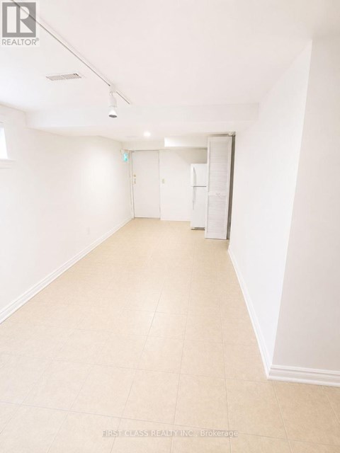 A white room with a tiled floor and a door on the right.