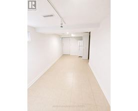 A long, empty hallway with white walls and tiled flooring.