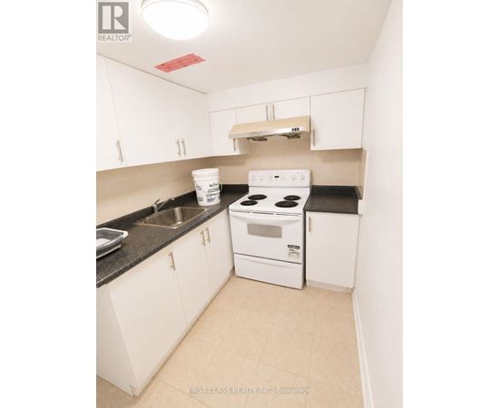 A small white kitchen with a stove and sink.