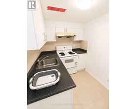 A kitchen with white cabinets and a black counter top.