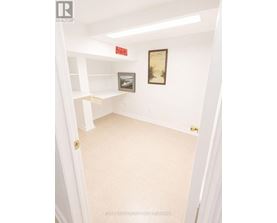A white hallway with a painting on the wall.